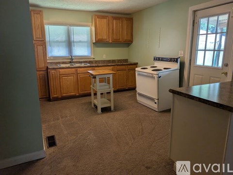 A kitchen with a white stove and wooden cabinets.