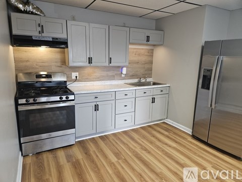 A kitchen with white cabinets and a wooden floor.