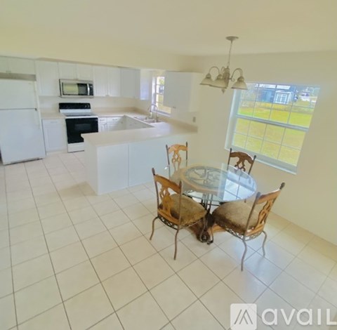 A kitchen with a table and chairs in the middle of the room.