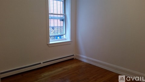 A room with a window and wooden flooring.