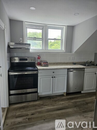 A kitchen with a stainless steel oven and a window.