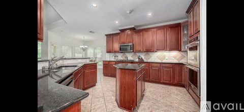 A kitchen with wooden cabinets and a black countertop.