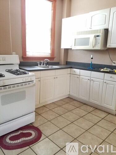 A kitchen with a white stove and cabinets.