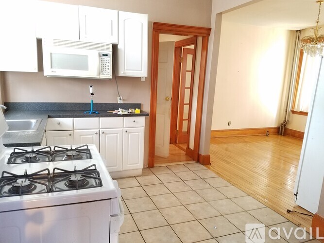 A kitchen with a white stove and a white microwave above the stove.