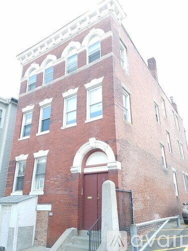 A red brick building with a white door and windows.
