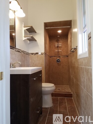 A bathroom with a toilet, sink, and shower.