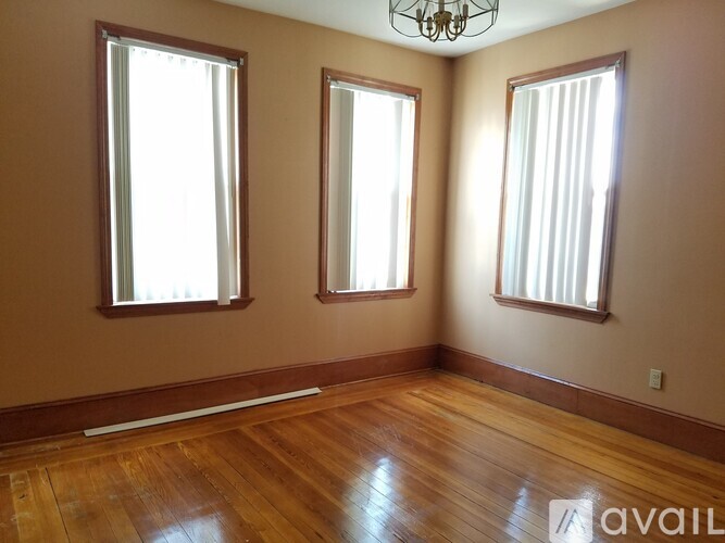 A room with wooden floors and two windows.