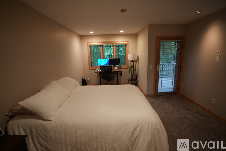 A bedroom with a large bed and a desk with a computer.