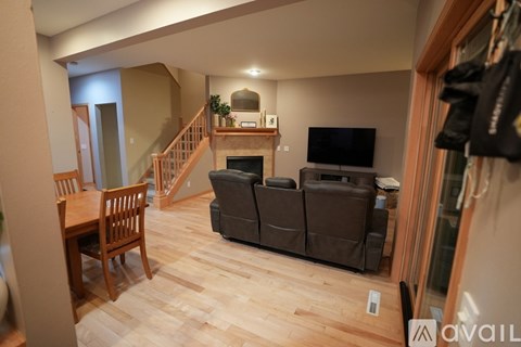 A living room with a brown couch and a wooden table.