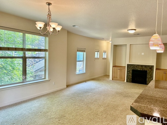 A living room with a fireplace and a large window.