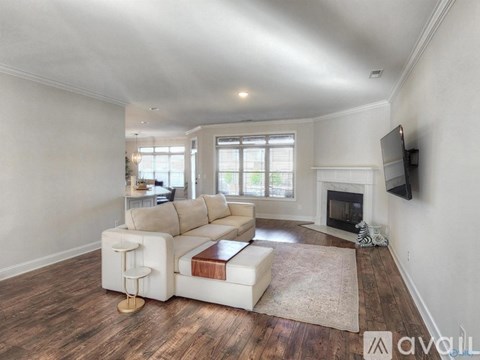 A living room with a white couch and a fireplace.