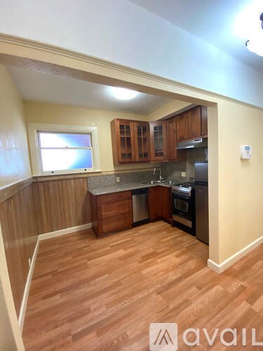 A kitchen with wooden cabinets and a window.