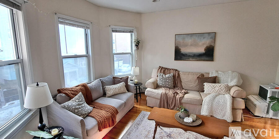 A living room with a couch, a coffee table, and a painting on the wall.