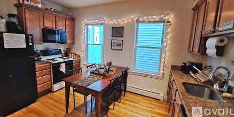 A kitchen with wooden cabinets and a black refrigerator.