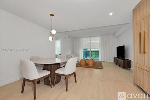 A modern dining room with a round table and chairs.