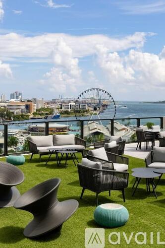 A lawn with chairs and a Ferris wheel in the background.