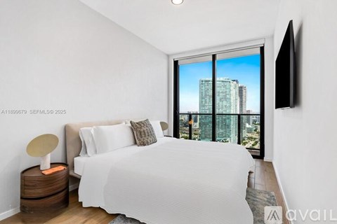 A bedroom with a large bed and a flat screen TV mounted on the wall.