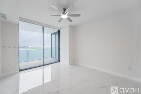 A spacious room with a ceiling fan and marble flooring.