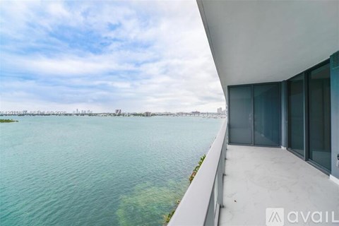 A modern building with a balcony overlooking a body of water.