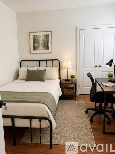 A bedroom with a bed, desk, and chair.