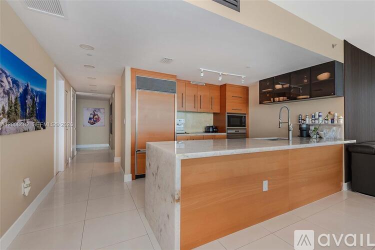 A kitchen with a wooden island and modern appliances.