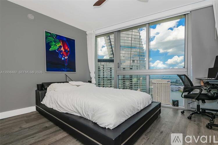 A bedroom with a large bed and a painting on the wall.