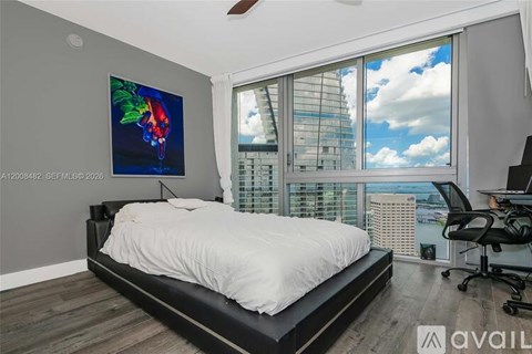 A bedroom with a large bed and a painting on the wall.