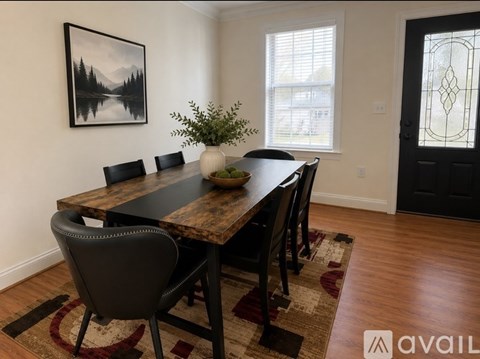 A dining room with a wooden table and chairs.