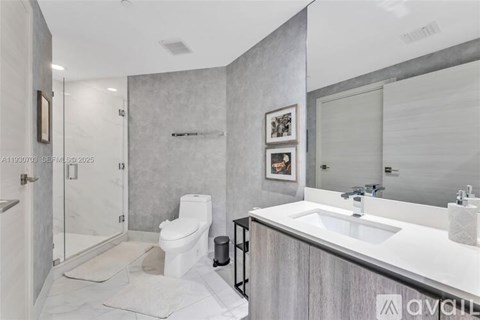 A bathroom with a toilet, sink, and mirror.