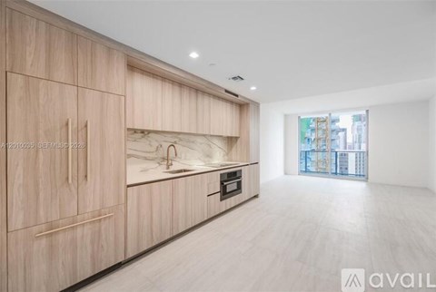A modern kitchen with wooden cabinets and a marble backsplash is available.