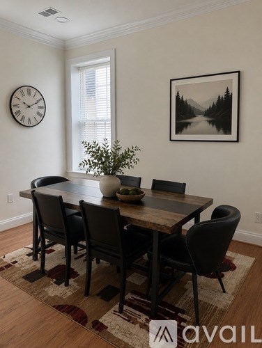 A dining room with a wooden table and chairs.