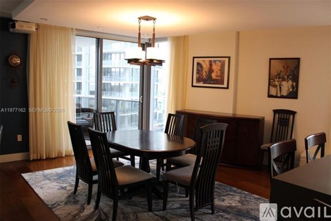 A dining room with a round table and chairs.