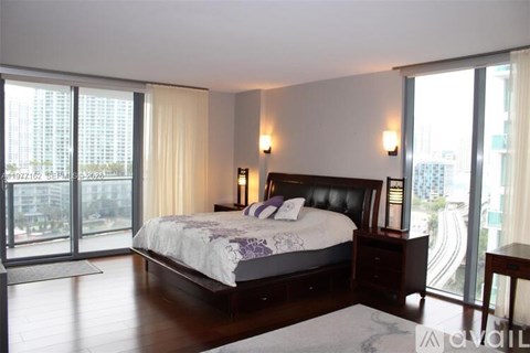 A bedroom with a large bed and a view of the city.