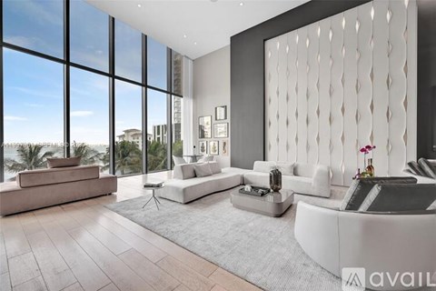 A modern living room with a large window overlooking a beach.