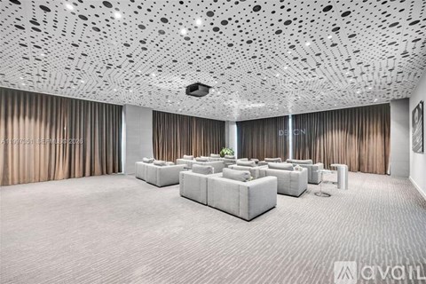 A spacious room with a patterned ceiling and a long table with chairs.