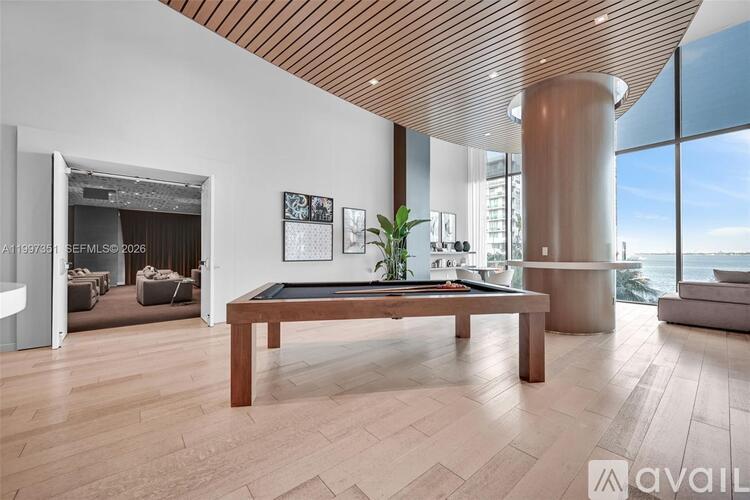 A modern living room with a wooden floor and a large window.