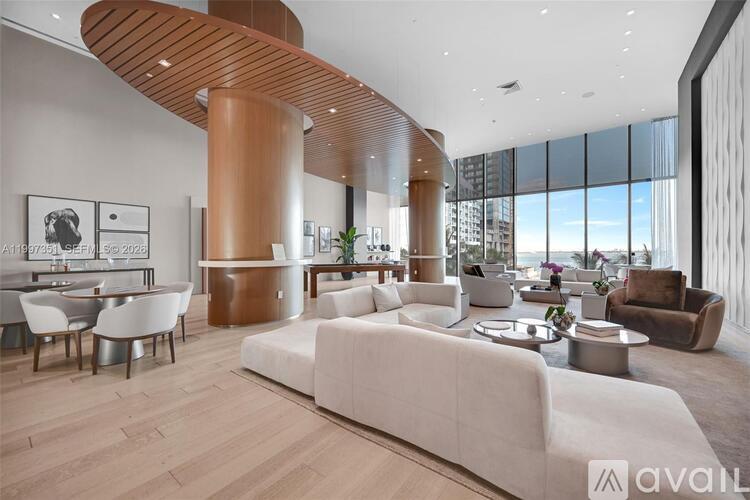 A modern living room with a large white sofa and a wooden curved structure.