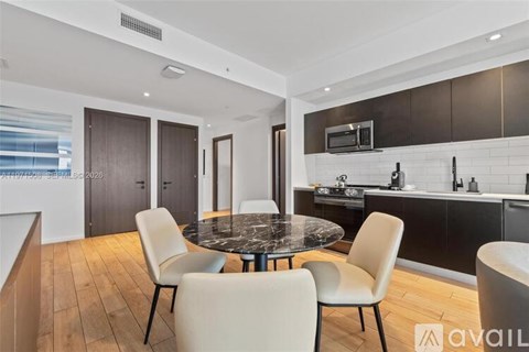 A modern kitchen with a round table and chairs.