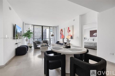 A modern living room with a white table and black chairs.