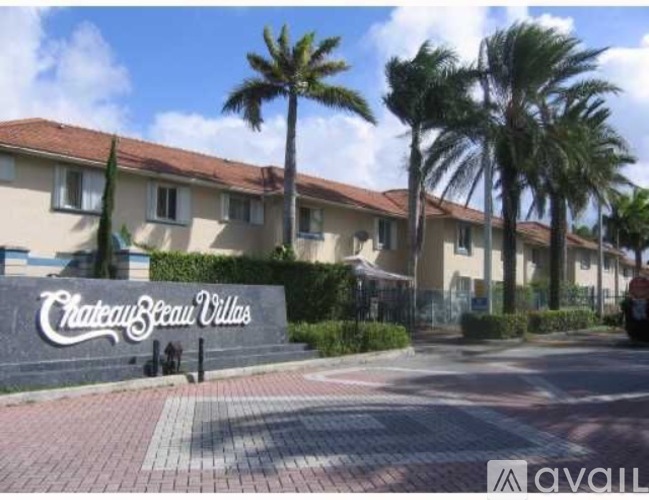 A street view of a residential area with a sign that reads "Chateau Beau Vilas".
