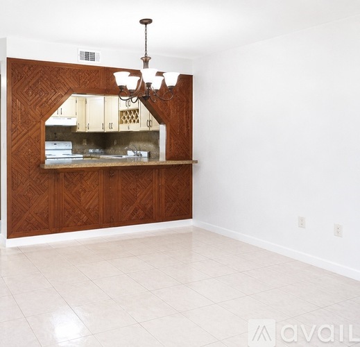 A room with a wooden panelled wall and a chandelier hanging from the ceiling.