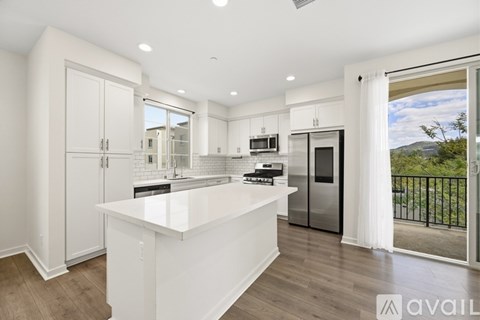 A modern kitchen with white cabinets and a large island.
