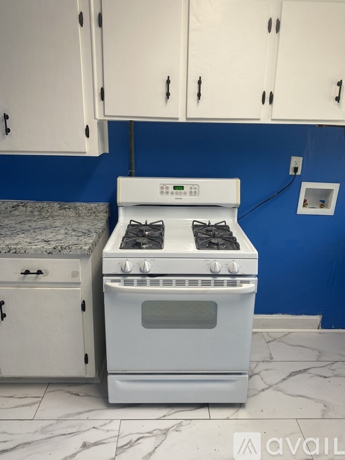 A white stove in a kitchen with blue walls.