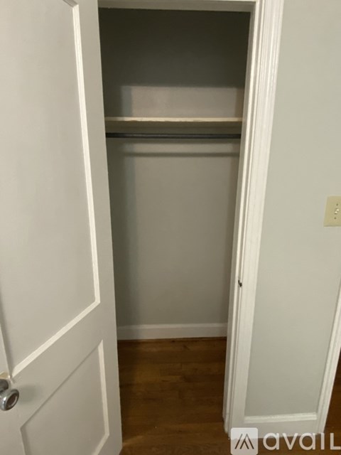 A white door with a silver handle is open.