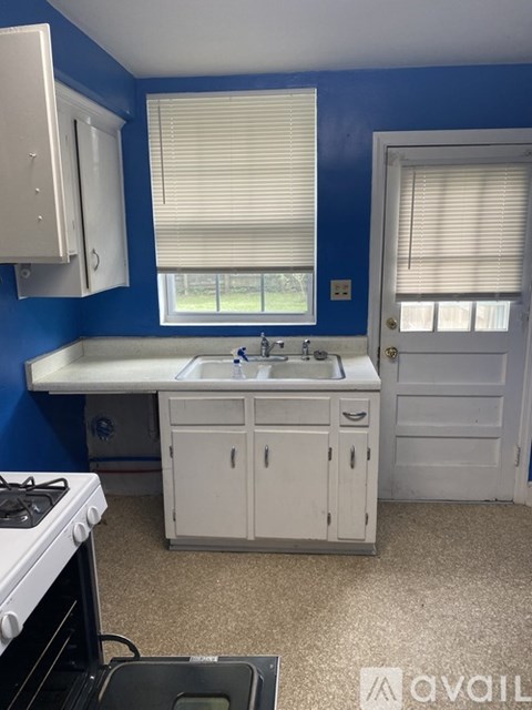 A kitchen with blue walls and white appliances.
