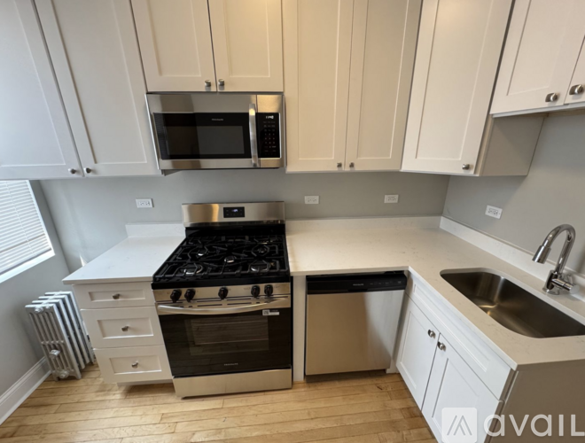 A kitchen with a stove, microwave, and cabinets.