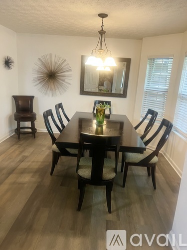A dining room with a wooden table and chairs.