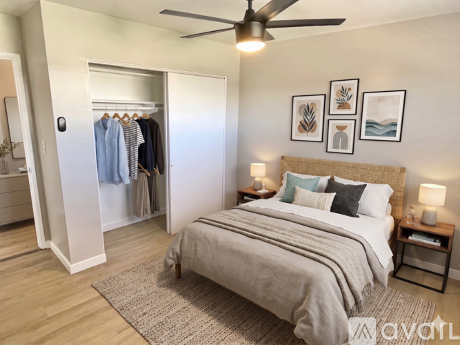 A bedroom with a bed, a ceiling fan, and a wardrobe.