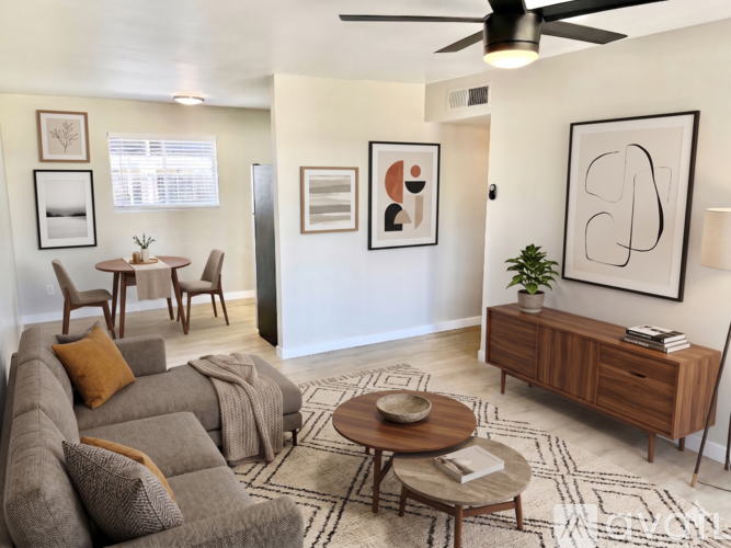 A living room with a grey couch, a coffee table, a side table, and a ceiling fan.