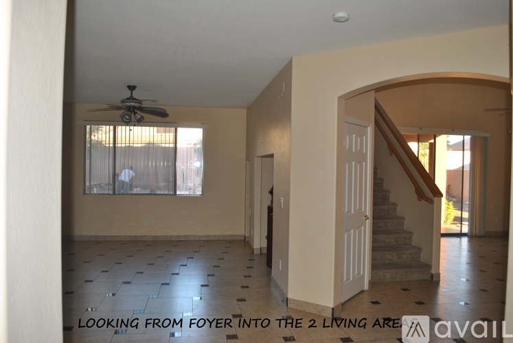 A living room with a fan and a staircase.